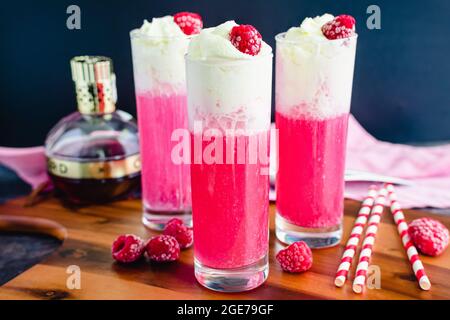 Italienische Himbeer-Creme-Limonaden mit Schlagsahne und gefrorenen Himbeeren: Süße italienische Limonaden mit Mineralwasser, Himbeeren und c Stockfoto