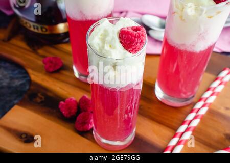 Italienische Himbeer-Creme-Limonaden mit Schlagsahne und gefrorenen Himbeeren: Süße italienische Limonaden mit Mineralwasser, Himbeeren und c Stockfoto