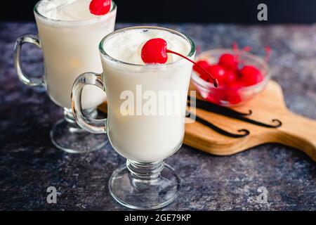 Vanilla Ital Cream Sodas garniert mit Maraschino-Kirschen: Vanilla Ital Sodas garniert mit Maraschino-Kirschen in Glaskrügen Stockfoto