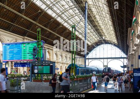 Im Inneren des 1884 erbauten Bahnhofs Keleti Palyaudvar mit Zügen und Passagieren, Budapest, Ungarn Stockfoto