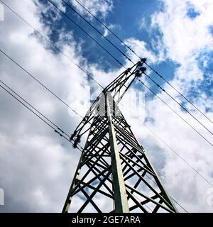 Hochspannungs-elektrische Türme und Linien mit blauem Himmel und Wolken. Eletricity Türme mit blauem Himmel Hintergrund. Hochspannungsübertragungsleitungen. Stockfoto