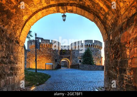 Nachtszene in Kalemegdan ein großer Park über den Ruinen der Belgrader Festung, Serbien, mit dem Zindan-Tor, das bei Sonnenuntergang vom Leopold-Tor aus gesehen wird. Stockfoto