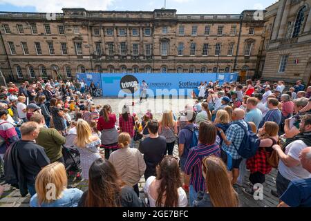 Edinburgh, Schottland, Großbritannien. August 2021. Eine große Menschenmenge sieht sich eine Aufführung auf dem West Parliament Square in der Altstadt von einem Straßenkünstler während des Edinburgh Festival Fringe 2021 an. Iain Masterton/Alamy Live Nachrichten. Stockfoto