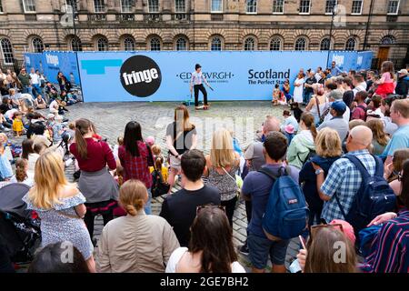 Edinburgh, Schottland, Großbritannien. August 2021. Eine große Menschenmenge sieht sich eine Aufführung auf dem West Parliament Square in der Altstadt von einem Straßenkünstler während des Edinburgh Festival Fringe 2021 an. Iain Masterton/Alamy Live Nachrichten. Stockfoto