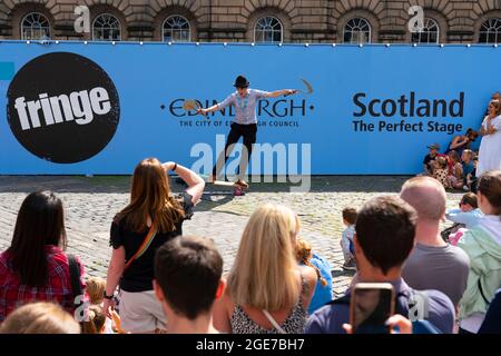 Edinburgh, Schottland, Großbritannien. August 2021. Eine große Menschenmenge sieht sich eine Aufführung auf dem West Parliament Square in der Altstadt von einem Straßenkünstler während des Edinburgh Festival Fringe 2021 an. Iain Masterton/Alamy Live Nachrichten. Stockfoto