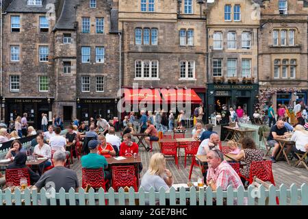 Edinburgh, Schottland, Großbritannien. August 2021. Die Nachrichten, dass Lieferkettenprobleme in Schottland zu einem Biermangel führen könnten, haben viele Besucher in der Altstadt von Edinburgh nicht davon abschrecken lassen, einen warmen Nachmittag bei Sonnenschein in einer der vielen Bars im Freien der Stadt zu genießen. Bild: Die Biergärten in Grassmarket waren sehr voll. Iain Masterton/Alamy Live Nachrichten. Stockfoto