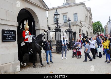 London, Großbritannien. Bewacht von zwei berittenen Kavallerietruppen des Rettungsschutzes der Königin. Die Parade der Pferdewächter bestiegen Kavalleriebesucher in Whitehall. Trafalgar Square im Londoner West End ist während der Schulferien sehr voll. Kredit: JOHNNY ARMSTEAD/Alamy Live Nachrichten Stockfoto