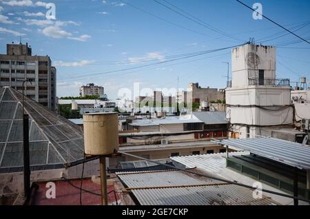 Blick auf Dächer und mehrstöckige Wohngebäude im Stadtzentrum von Mendoza, Argentinien. Viele Elektrokabel und Drähte über Dächern Stockfoto