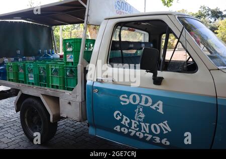 Mendoza, Argentinien - Januar, 2020: LKW liefert abgefülltes Wasser. Offener Anhänger-LKW entlädt Trinkwasser in großen Flaschen und grünen Boxen mit Soda Stockfoto