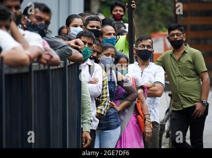 Mumbai, Indien. August 2021. Maskierte Menschen stehen in einer Schlange vor dem Juhu PVR-Multiplex für die Covid-19-Impfung in Mumbai. Nur vollständig geimpfte Personen dürfen in Mumbai Einkaufszentren betreten und mit den örtlichen Zügen fahren. Kredit: SOPA Images Limited/Alamy Live Nachrichten Stockfoto