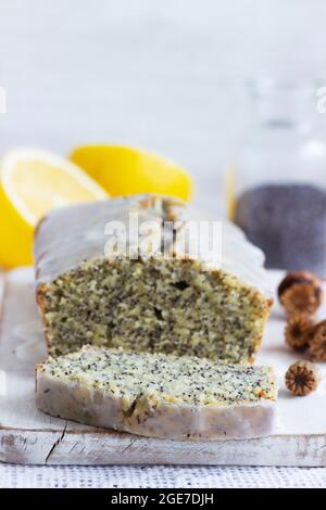 Zitronenkuchen mit Mohnsamen, bedeckt mit Glasur auf hellem Hintergrund. Stockfoto