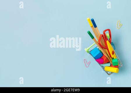 Schulbedarf und Büroklammer auf blauem Hintergrund. Zurück zum Schulkonzept. Vorsichtsmaßnahmen für COVID-19. Draufsicht flach lay Hintergrund. Speicherplatz kopieren. Stockfoto