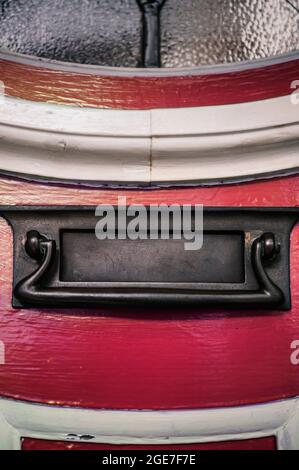 Detail eines Briefkastens in der roten Haustür eines Hauses Stockfoto