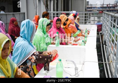 Dhaka, Bangladesch. August 2021. Mitarbeiter von Ready-Made Garment (RMG) waschen sich vor dem Mittagessen als Sicherheitsmaßnahme zur Reduzierung der Ausbreitung des Coronavirus in der Bekleidungsfabrik Civil Engineering Limited in Dhaka die Hände. Kredit: SOPA Images Limited/Alamy Live Nachrichten Stockfoto