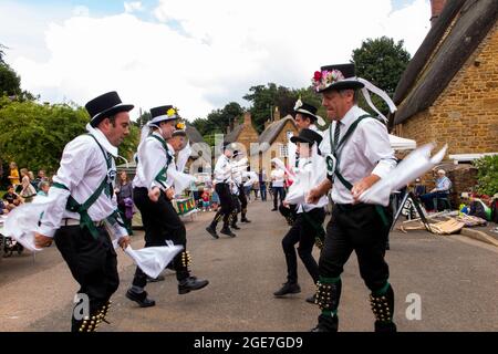 Großbritannien, England, Oxfordshire, Wroxton, jährliches Kirchenfest im Gange, Morris-Tänzer auf der Main Street, am Rande des Dorfgrüns Stockfoto