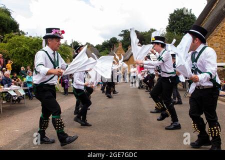 Großbritannien, England, Oxfordshire, Wroxton, jährliches Kirchenfest im Gange, Morris-Tänzer auf der Main Street, am Rande des Dorfgrüns Stockfoto