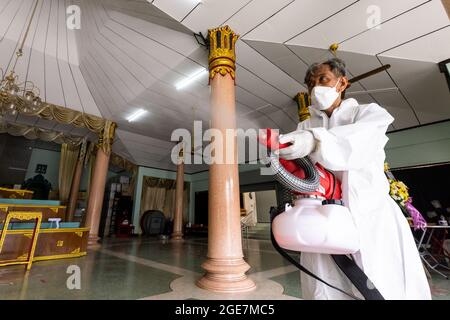 Thonburi, Bangkok, Thailand. Juli 2021. Ein Bestatter sah, wie er im Krematorium am Sutthawat Temple Alkohol sprühte.COVID Delta sich in Thailand mit 20,000 Infektionen und 200 Todesfällen pro Tag stark ausbreitete. Nur wenige Tempel akzeptieren COVID-19-Körper, die zu einem Mangel an Krematorien führen, um buddhistische Kremierungsrituale durchzuführen. (Bild: © Phobthum Yingpaiboonsuk/SOPA-Bilder über ZUMA Press Wire) Stockfoto