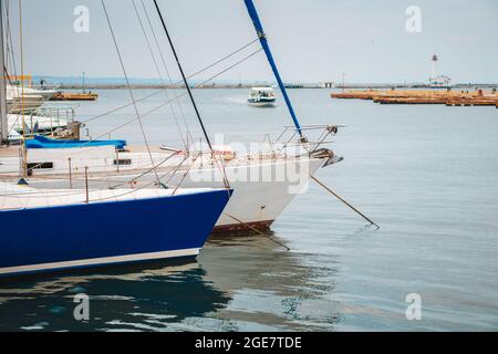 Moderne Yachten liegen am Hafen. Kleine private Boote zum Segeln und zur Erholung. Der Traum jedes Mannes. Stockfoto