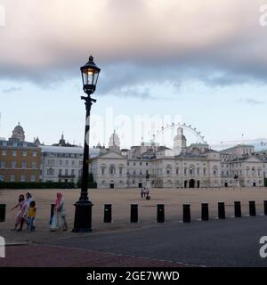 London, Greater London, England, August 10 2021: Dramatischer Himmel über der Horse Guards Parade und dem London Eye mit einem ethnischen Familienvorfeld. Stockfoto