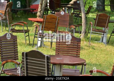 Zywiec. Bänke zwischen Bäumen und Gräsern mit dem Żywiec-Schild. Sommer. Stockfoto