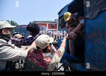 Srinagar, Indien. August 2021. Ein indischer Polizist hält einen schiitischen Mann aus Kaschmir während der Muharram-Prozession fest. Regierungskräfte griffen zu Pelletfeuern, schweren Tränengas-Beschuss, Schlagstock-Beschuss und Luftfeuern gegen schiitische Muslime zurück, als sie sich den Beschränkungen im Rahmen der Pro-Freiheit-Slogans widersetzten, die 8. Muharram-Prozession in Srinagar zu übernehmen. In der Zwischenzeit wurden Dutzende von Medienvertretern, darunter Fotojournalisten, von den Polizeikräften, die berufliche Aufgaben erfüllten, geschlagen. Kredit: SOPA Images Limited/Alamy Live Nachrichten Stockfoto