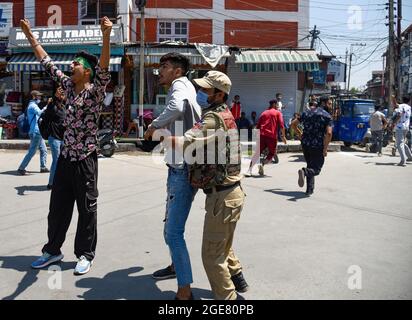 Srinagar, Indien. August 2021. Ein indischer Polizist hält einen schiitischen Mann aus Kaschmir während der Muharram-Prozession fest. Regierungskräfte griffen zu Pelletfeuern, schweren Tränengas-Beschuss, Schlagstock-Beschuss und Luftfeuern gegen schiitische Muslime zurück, als sie sich den Beschränkungen im Rahmen der Pro-Freiheit-Slogans widersetzten, die 8. Muharram-Prozession in Srinagar zu übernehmen. In der Zwischenzeit wurden Dutzende von Medienvertretern, darunter Fotojournalisten, von den Polizeikräften, die berufliche Aufgaben erfüllten, geschlagen. Kredit: SOPA Images Limited/Alamy Live Nachrichten Stockfoto