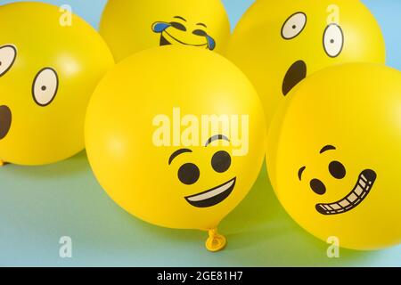 Gelbe Emoji-Ballons auf blauem Hintergrund. Stockfoto