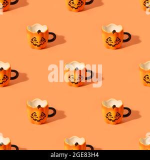 Nahtloses Muster leerer Halloween Fun Cups auf orangefarbenem Hintergrund. Stockfoto