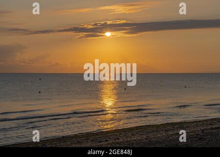 Langrune-Sur-Mer, Frankreich - 08 03 2021: Sonnenaufgang über dem Meer vom Strand Stockfoto