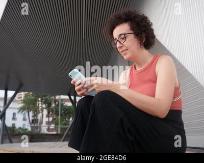 Kaukasische junge Frau in der Stadt mit Mobiltelefon Stockfoto