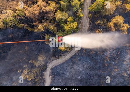 Antalya, Türkei. August 2021. US-Armeebesatzungen, die einen CH-47 Chinook-Hubschrauber fliegen, geben Wasser aus einem bambi-Eimer ab, während sie bei der Bekämpfung von Waldbränden in der Westtürkei helfen 15. August 2021 in der Nähe von Antalya, Türkei. Quelle: Planetpix/Alamy Live News Stockfoto