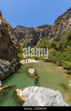 PREVELI, KRETA - JULI 21 2021: Menschenmassen erkunden den natürlichen Palmenwald und den Sandstrand von Preveli an der Südküste der griechischen Insel Stockfoto