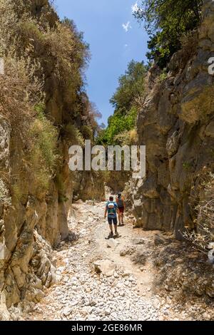 IMBROS-SCHLUCHT, KRETA - 23. JULI 2021: Wanderer erkunden die engen Schluchten und das Gelände der Imbros-Schlucht im Zentrum Kretas, Griechenland Stockfoto