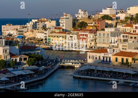 AGIOS NIKOLAOS, KRETA - 11. JULI 2021: Vouliagmeni-See und Uferbereich der Stadt Agios Nikolaos bei Sonnenuntergang. Kreta, Griechenland. Stockfoto