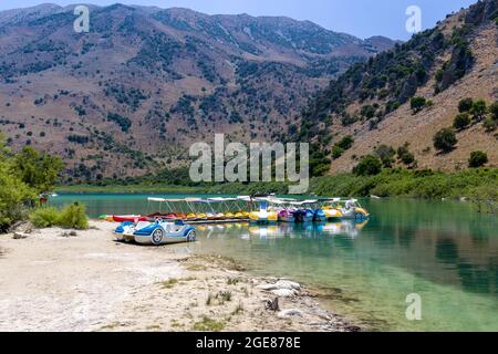 KOURNAS, KRETA - 17. JULI 2021: Tretboote und kleine Boote am Kournas See - dem größten Süßwassersee Kretas Stockfoto