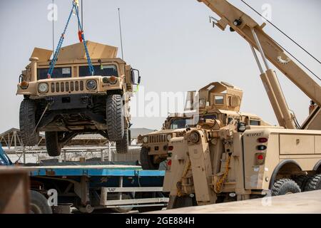 US-Soldaten und Auftragnehmer laden hochmobile Mehrzweckfahrzeuge, HUMVs, ein, die zur Unterstützung der Rückfahrmission Resolute Support in Afghanistan, 13. Juli 2020, zum Transport geschickt werden. (USA Armeefoto von Sgt. Jeffery J. Harris) Stockfoto