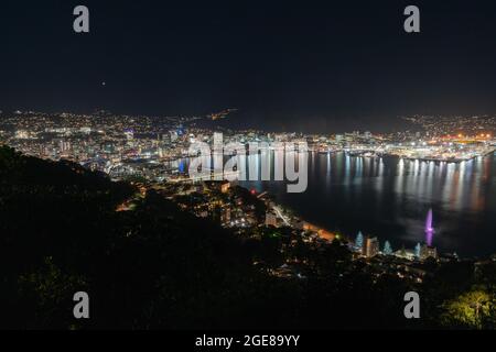 Wellington City Helle Lichter rund um den Hafen, aufgenommen vom Mount Victoria mit Farben von Lichtern, die sich im Wasser spiegeln., Neuseeland. Stockfoto