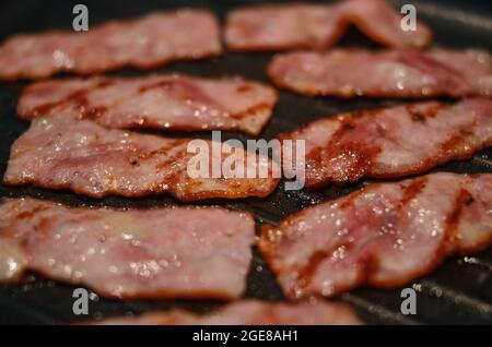 Nahaufnahme von gegrilltem Speck auf der Bratpfanne Stockfoto