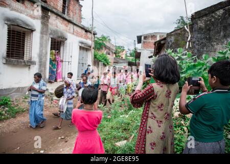 Die Dorfbewohner feierten die Göttin Manasa (die Hindu-Serpentine-Göttin) Puja. Als Teil des Rituals fangen Anhänger vor dem Gottesdienst giftige Schlangen (meist Kobra) von Reisfeldern, Schlangenzähne werden von Schlangenbeschwörern entfernt und bei ihren Hütten behalten und später als Teil traditioneller Rituale verehrt. Dieses Festival ist bekannt als 'Jhapan'. Das Jhapan-Fest wird jedes Jahr am 17. August anlässlich der Göttin Manasa Puja gefeiert. Das Jhapan Festival ist das größte Schlangenfestival von Jharkhand und Bengalen. Während der Manasa Puja-Feier können Schlangenbeschwörer mit der giftigen Schlange mithalten Stockfoto