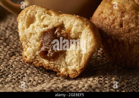 Nahaufnahme von leckeren Muffins, gefüllt mit Dulce de leche Karamell auf einer Sackleinen-Oberfläche Stockfoto