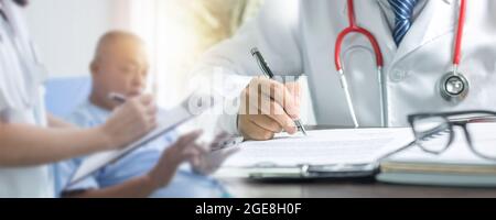 Nahaufnahme der Hand des Arztes Schreiben und Auffüllen auf Papier zur Behandlung nach Überprüfung und Geschichte Gespräch mit dem Patienten Stockfoto