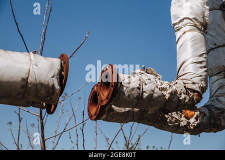 Defekte Wärmedämmung der Stadtwasserversorgung. Veraltete Technologie. Zerstörte Infrastruktur, oberirdische Wärmerohre. Stockfoto