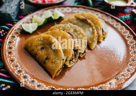 Gebratene oder gebräunte mexikanische Tacos mit Zitrone und Salsa, traditionelle mexikanische Küche in Mexiko Stockfoto