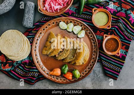 Gebratene oder gebräunte mexikanische Tacos mit Zitrone und Salsa, traditionelle mexikanische Küche in Mexiko Stockfoto