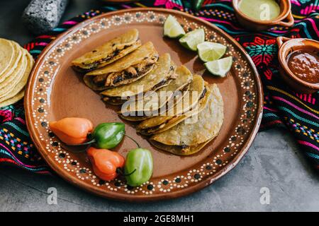 Gebratene oder gebräunte mexikanische Tacos mit Zitrone und Salsa, traditionelle mexikanische Küche in Mexiko Stockfoto