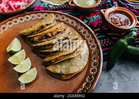 Gebratene oder gebräunte mexikanische Tacos mit Zitrone und Salsa, traditionelle mexikanische Küche in Mexiko Stockfoto