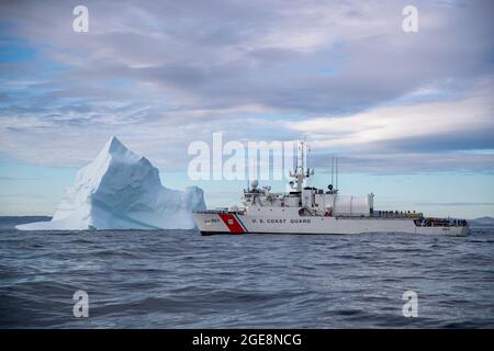 NUUK, Grönland -- (Aug 13, 2021) die USCGC Escanaba (WMEC 907) segelt an einem Eisberg in der Labradorsee vorbei. Die Escanaba ist ein 270 Meter langer, berühmter Mittelausdauerschneider mit einer Besatzung von rund 100 Mitarbeitern, die viele Missionen des Dienstes durchführt und dabei auf Strafverfolgung und Sicherheit setzt. (USA Foto der Küstenwache von Petty Officer, 3. Klasse, Dyxan Williams) Stockfoto