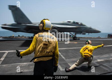 210817-N-WS494-1060 ARABIAN SEA (AUG 17, 2021) – Aviation Boatswain’s Mate (Handling) 3rd Class Zachary Fite, links, Und LT. Jonathan Tohill leiten einen F/A-18F Super Hornet Kampfjet, der an den „Diamondbacks“ von Strike Fighter Squadron (VFA) 102 befestigt ist, um am 17. August vom Flugdeck des Flugzeugträgers USS Ronald Reagan (CVN 76) im Arabischen Meer zu starten. Ronald Reagan wird im Einsatzgebiet der 5. US-Flotte eingesetzt, um Marineinteraktionen zu unterstützen, um die maritime Stabilität und Sicherheit in der Zentralregion zu gewährleisten und das Mittelmeer und den Pazifik durch den westlichen Indischen Ozean und zu verbinden Stockfoto