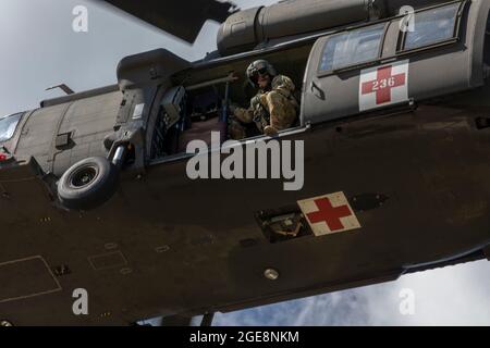 Sgt. Joseph Brovton, ein Flugmediziner der C Company, 5/159. General Support Aviation Bataillon, bereitet sich auf die Landung während des Mülllasttrainings für das 348. Field Hospital in Fort McCoy, Wisconsin, vor, 13. August 2021. Diese von der 78th Training Division durchgeführte Rotation des Combat Support Training bereitet Soldaten durch Szenarien vor, die den Einsatz von Konflikten gegen einen gleichrangigen Gegner simulieren. (FOTO DER US Army Reserve von Sgt. Sarah Martens) Stockfoto