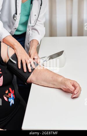 Eine Ärztin misst den Blutdruck eines Patienten Stockfoto